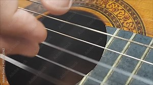man playing arpeggio with acoustic guitar