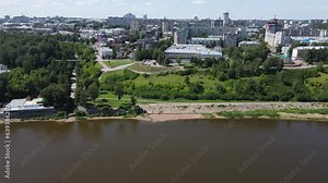 green riverside promenade with park near residential houses against the city