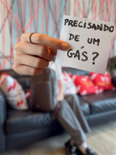 O Pedir Gás é exatamente o que você precisa no seu dia a dia: facilidade, rapidez e segurança, tudo no mesmo app! #DescriçãoDoVídeo: o vídeo começa com a imagem de uma mulher jovem, de cabelos escuros e camiseta branca, sentada em um sofá preto. Atrás dela, há uma decoração moderna com fios vermelhos e pretos esticados na parede e almofadas personalizadas da Supergasbras. Ela sorri e tira um bilhete de uma mochila marrom que está em seu colo. Um close no bilhete escrito à mão: