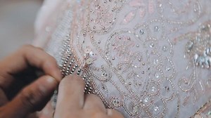 Download A skilled dressmaker fitting a dress on a mannequin, exhibiting utmost care and detail. for free