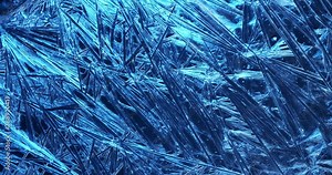 Frost covered window with lights shimmering and glittering over ice crystals.