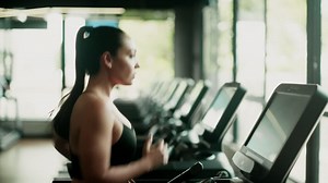 Woman exercising on a treadmill in a gym - Free Stock Video
