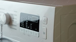 Pressing the start button on the washing machine close-up Stock Video
