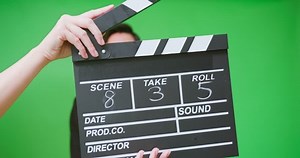 clapperboard on set - portrait asian businessman wear black suit hosting tv show or advertisement in front of green screen