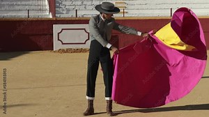 Bullfighter dressed in traditional matador costume from southern spain practicing with the cape in a bullring