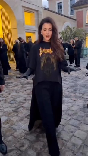 @annehathaway arrived for tonight’s @balenciaga Spring 2026 runway show in Paris wearing #Balenciaga — pairing a graphic tee with sleek black trousers and pointed pumps for a look that blended rocker edge with effortless sophistication. Hot! Or Hmm..? 📸: WWD #AnneHathaway #Balenciaga #ParisFashionWeek #fashionbombdaily #fbdaily #annehathawayfbd | Fashion Bomb Daily