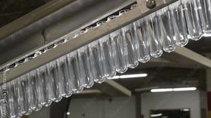 Plastic PET preforms are moving along a robotized equipment line into a new technological process