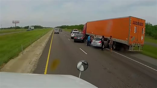 A violent impact left this car trapped under a semi trailer