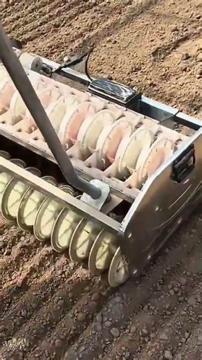 Manual seed planting machine making rows in soil