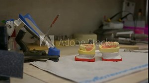Producing the fake teeth at the dentistry laboratory. Dentistry specialists making the fake teeth for oral care treatment. Crafting the fake teeth for dentistry prosthetic restorations. Stomatology.