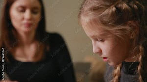 Mother and daughter doing a school homework assignment. Mom helps to deal with it.