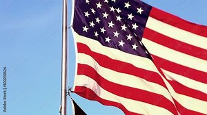 Close-up tilt shot of American and POW/MIA flags flying over Korean War Veterans Memorial