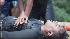 Asian Lifeguard Performing CPR Chest Compressions On A Drowning Person
