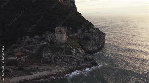 Aerial view of Sabaudia beach and Monte Circeo at sunset, featuring the historic Torre Paola watchtower. Cinematic drone shot of the Lazio coast, sandy dunes, and Mediterranean sea in Italy.