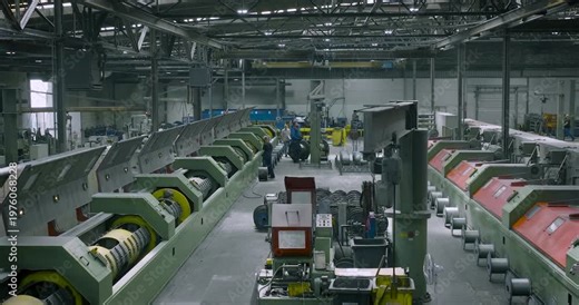Interior wide shot of a large industrial factory floor with heavy machinery for wire rope production