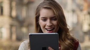 Woman checking email by tablet outdoors. Happy girl looking tablet screen