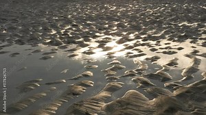 Tidal shapes of sand on the ocean coast and sun reflection 4K 3840X2160 UltraHD video - Wet sand and water after tide ebb near ocean water 4K 2160p 30fps UHD footage