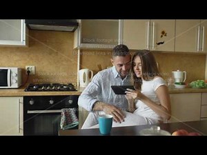 Attractive couple meet in the kitchen early morning and using digital tablet computer for social