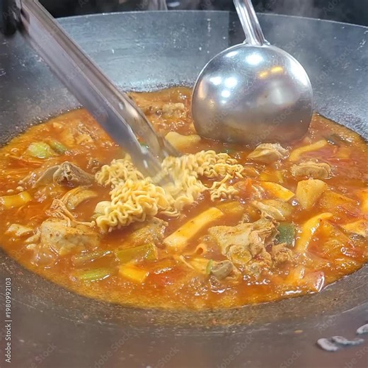 Spicy Korean Braised Chicken Dak-bokkeum-tang Boiling in a Cauldron with Ramen Noodles