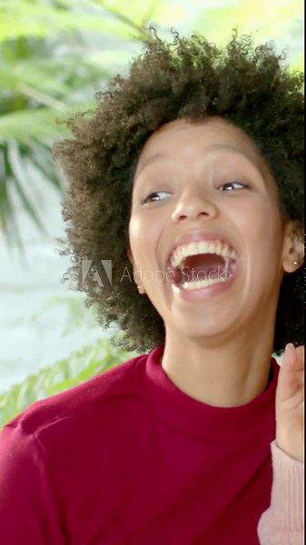 Vertical video: Puckering lips, two women mirroring OK signs then laughing at home, pink sweater