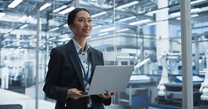 clip-1111286067-experienced-female-engineer-standing-office-using-laptop