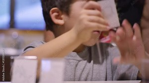 A boy putting homemade name tags into plastic holders