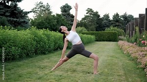 Yoga instructor demonstrating variations of utthita trikonasana in a peaceful garden, enveloped by nature and a sense of calm