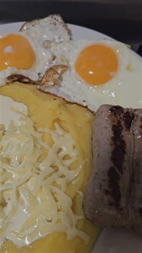 Polenta served with sausages and fried eggs