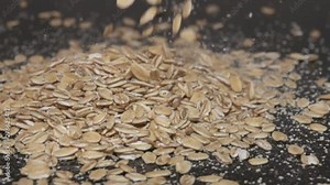 Oat flakes fall on the wooden table. Oatmeal as an internationally recognized healthy food for Breakfast. Super slow motion 1000 fps