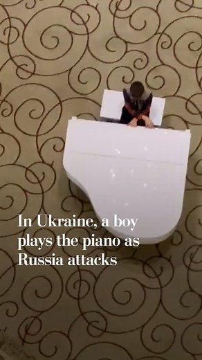 As reports came in that Russian troops were advancing on Kharkiv, Washington Post video journalist Whitney Leaming captured a video of a young boy playing the piano in a hotel there. The boy is playing a song composed by Philip Glass and Paul Leonard-Morgan for “Tales from the Loop,” an Amazon original series about people who live above a machine built to unlock the mysteries of the universe, according to the series description. The series is based on the paintings of Simon Stalenhag. Russia lau