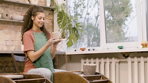 Free stock video - Clerk woman modeling ceramic piece on a potter wheel in a workshop 3