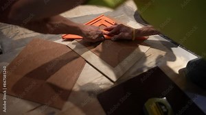 Scoring, cutting and breaking a vinyl composition tile, VCT to fit into a section of wall for a home renovation project.