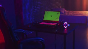 Gaming laptop green screen in a dark, dimly lit room - Free Stock Video