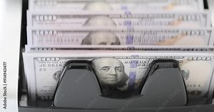 Bank worker hands operate banknote counter machine preparing cash for client. Specialized device rapidly counts dollar bills without errors