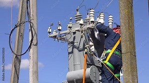 Remont power transformer. Maintenance of overhead power lines. Electrician lineman repairman worker at climbing work on electric post power pole and change transformer.