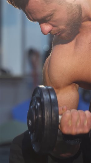 Young muscular man training hard at the gym. Bodybuilding man training his biceps. Vertical video | Premium Stock Video Footage