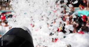 Foam party and soap bubbles in water park in pool. Summer festival and entertainment in water park