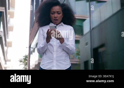 Shocked displeased African American business woman with smartphone city upset businesswoman female bad news outdoors girl worker employee use mobile phone error message failure problem downtown urban Stock Video Footage - Alamy