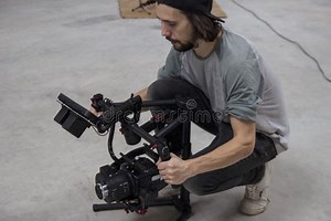Professional Videographer Holding Camera on 3-axis Gimbal. Videographer Using Steadicam Stock Photo - Image of equipment, lens: 130237546