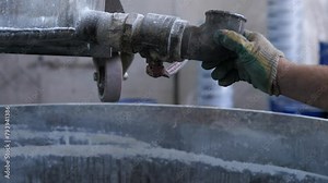 toxic flammable liquid is poured from a technical tap into industrial container