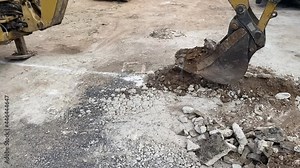 the excavator bucket digging and piling the ground material in HD