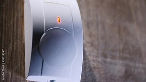 The house alarm is on the wall. The red motion sensor trigger is lit