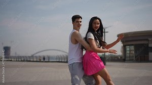 Complex elements of street dance performed by talented dancers. A guy and a girl beautifully and skillfully perform complex dance movements. The couple looks at the camera, smiling