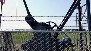 Crank and V-belt rotate on active pumpjack in Alberta oil fields.