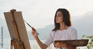 Multiethnic female artist relaxing in mountains, making a picture inspired by beautiul view - recreational pursuit, hobby, inspirational landscape concept 4k footage
