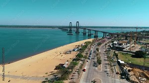 A panoramic view of the city of Corrientes, its beach, riverside promenade (costanera), and the bridge connecting it to Resistencia, highlighting the beauty of this Argentinean urban landscape.