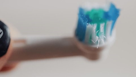 clip-4007351321-applying-toothpaste-electric-toothbrush-head-close