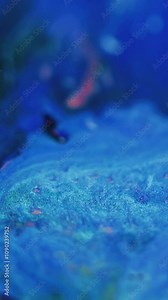 Vertical video. Paint splash. Ink mix water. Defocused blue pink color shimmering particles texture fluid spill flow motion abstract art background.