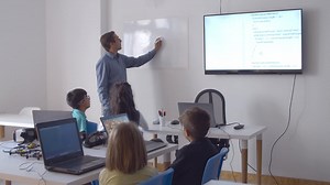 Premium stock video - Computer science teacher writing on whiteboard