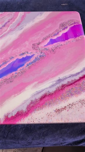 ✨ THE REAL DIFFERENCE BETWEEN EPOXY TOPCOATS ✨ Not all epoxies are created equal—especially when it comes to topcoats. For this candy-style table 🍭 with pink, white, purple, and glitter, we needed time to play with layers and effects. ⚡ Table Top Epoxy → thicker, sets faster, perfect for protection but not for complex designs. 🎨 Designer Art Resin → thinner, longer working time, naturally creates cells, and lets you move colors around for depth. The extra working time is what allowed us to cre